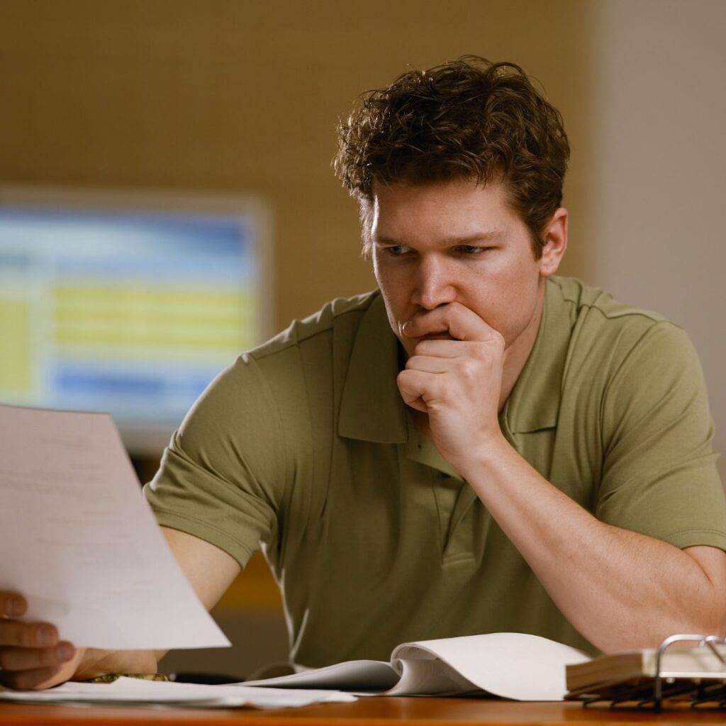 a man looking at paperwork thoughtfully