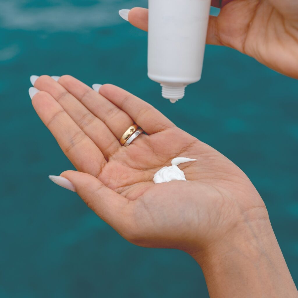 Woman applying sunscreen on the water